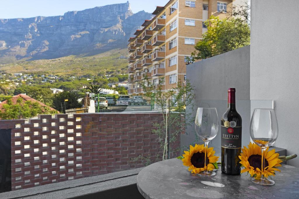 einen Tisch mit einer Flasche Wein und zwei Gläsern in der Unterkunft The Cedar Unit 101 in Kapstadt