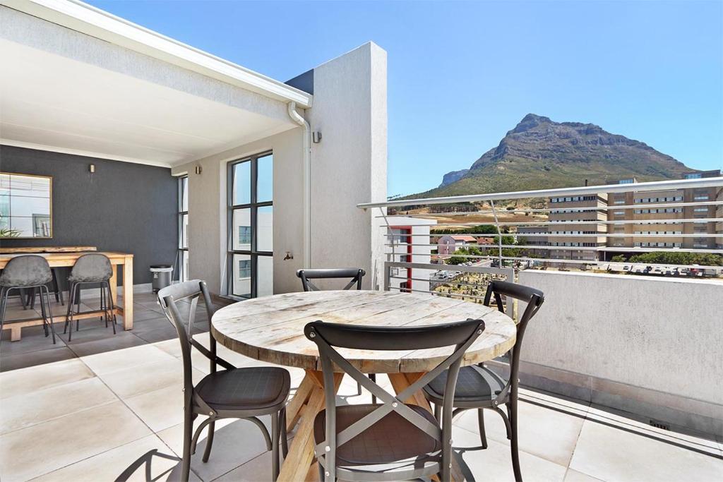 a patio with a table and chairs on a balcony at The Paragon 317 by HostAgents in Cape Town