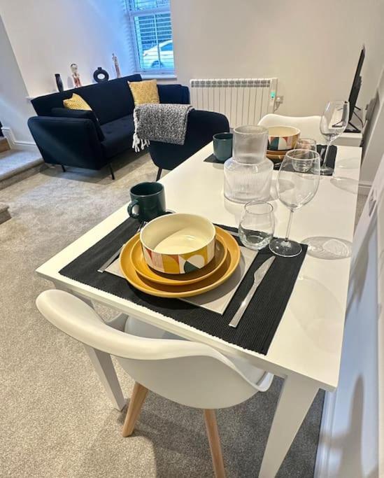a white table with a hat and glasses on it at Spacious and Stylish Flat in Trowbridge, Wiltshire in Trowbridge
