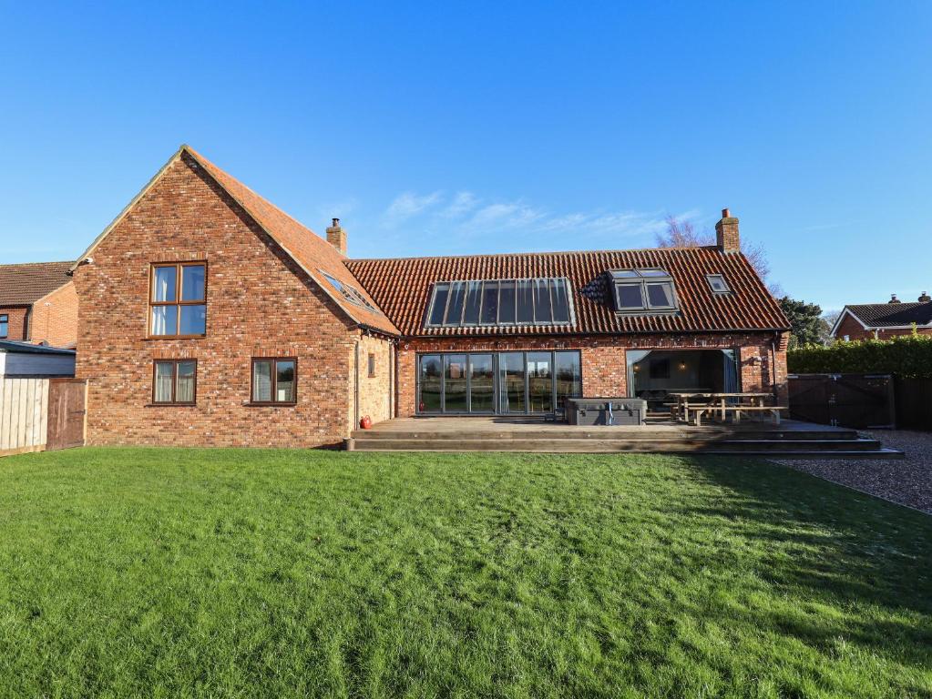 a large brick house with a lawn in front of it at Brambleberry Barn in Spilsby