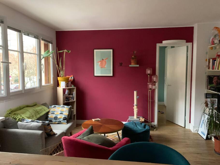 - un salon avec un mur violet dans l'établissement Appartement calme - Parking - Métro, à Ivry-sur-Seine
