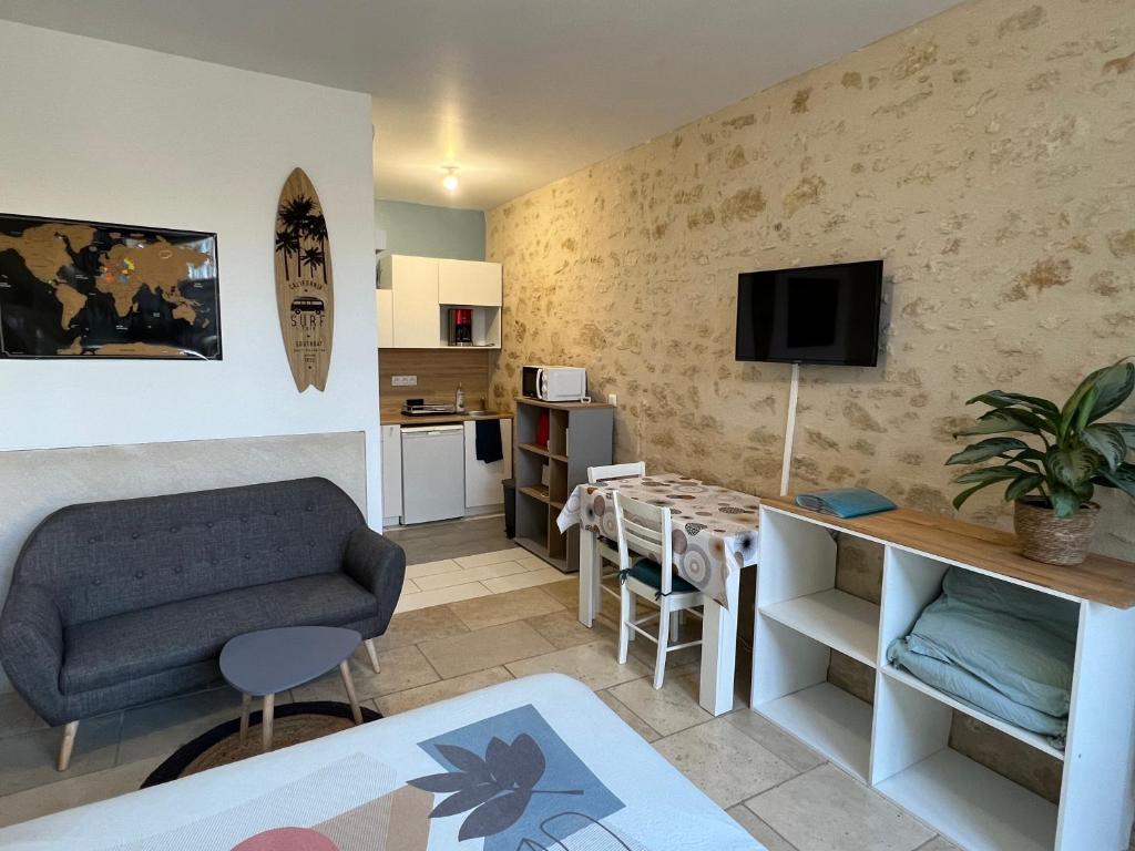 a living room with a couch and a table at Guest House de Céline et Benoît in Rivarennes