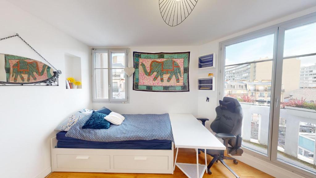 sypialnia z łóżkiem, biurkiem i oknami w obiekcie Boho studio near the Eiffel Tower w Paryżu