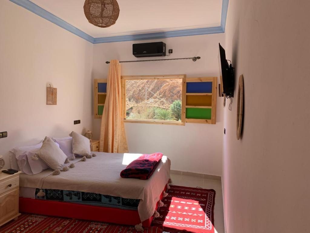 een slaapkamer met een bed en een raam bij Dar Ayour Todra Gorges in Aït Baha