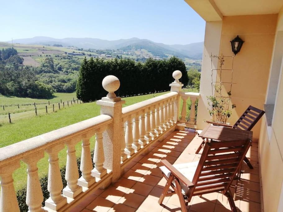 a balcony with two chairs and a view of the mountains at Camino de las Mimosas: relax en un entorno idílico in Folgueras
