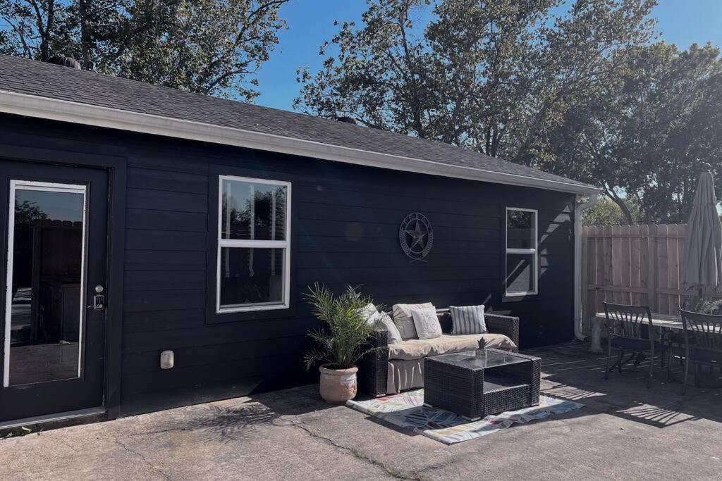 ein schwarzes Haus mit einer Couch auf einer Terrasse in der Unterkunft Quiet, Cozy Guesthouse with privacy in Manvel