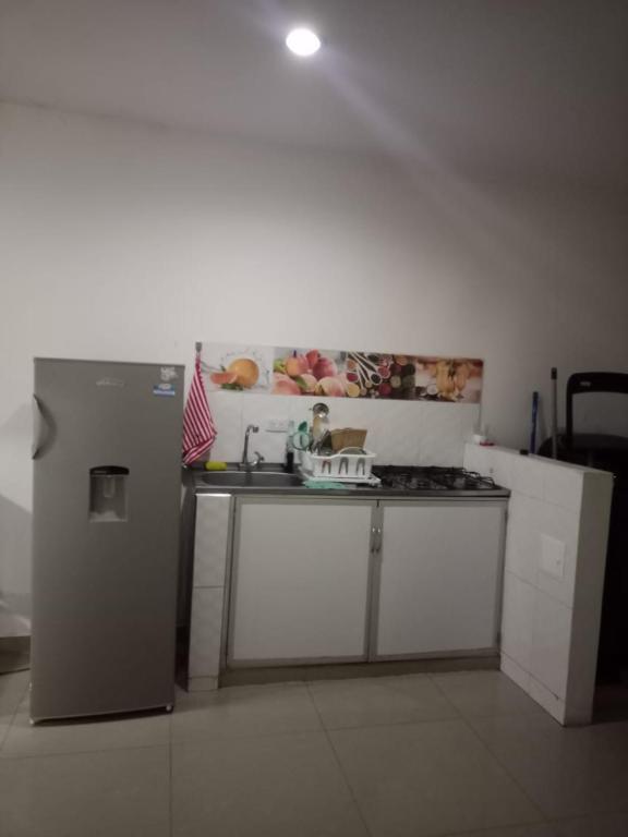 a kitchen with a sink and a refrigerator at Apartaestudio G&J in Neiva