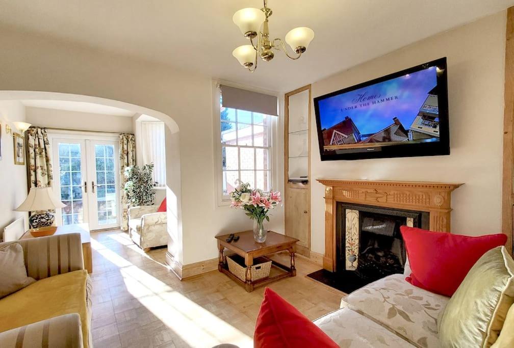 ein Wohnzimmer mit einem Kamin und einem Flachbild-TV in der Unterkunft Shrewsbury 3 Bedroom Abbey Foregate in Shrewsbury