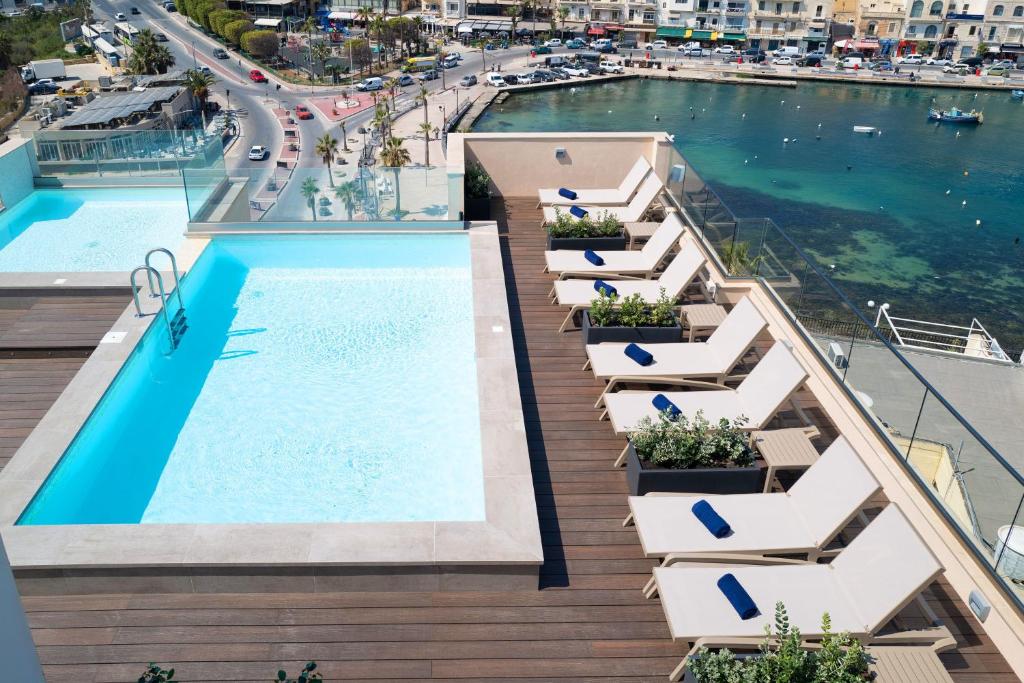 an apartment with a swimming pool on the roof of a building at Portside Lodge in Marsaskala