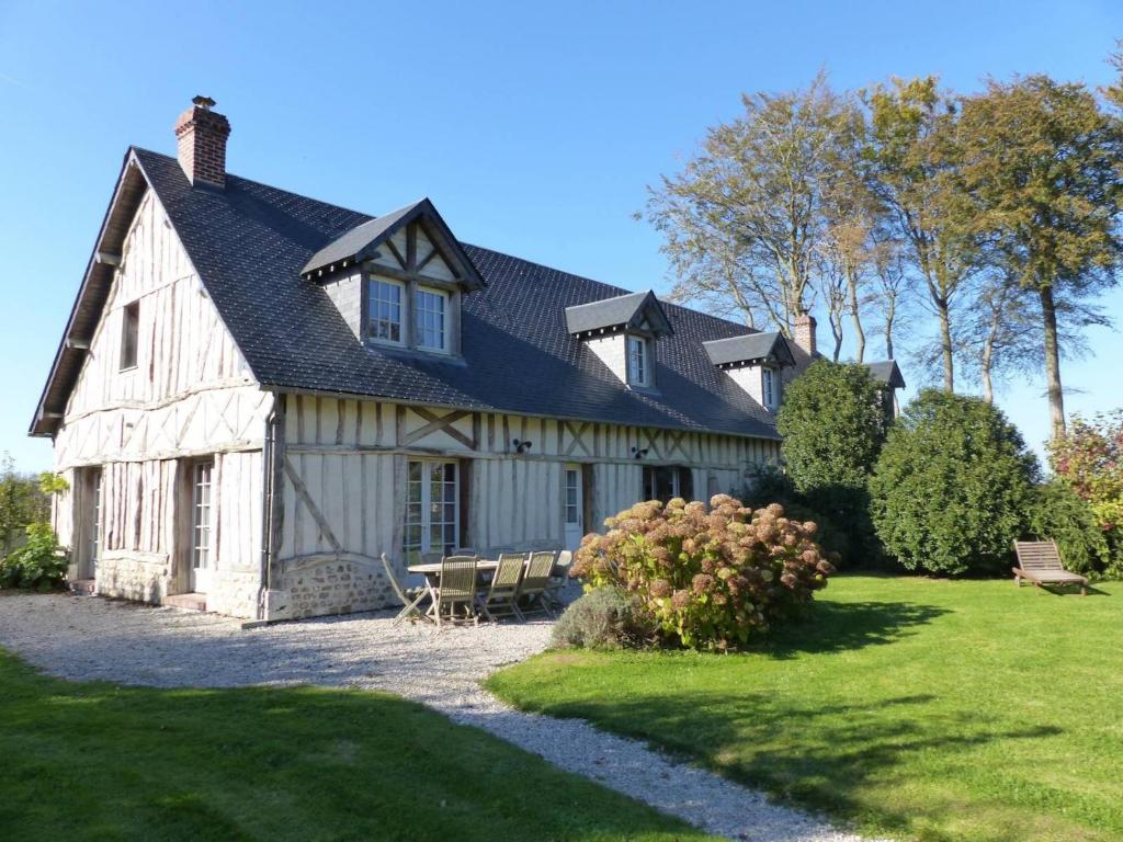 a large white barn with a table and chairs at Villas Les Loges in Les Loges