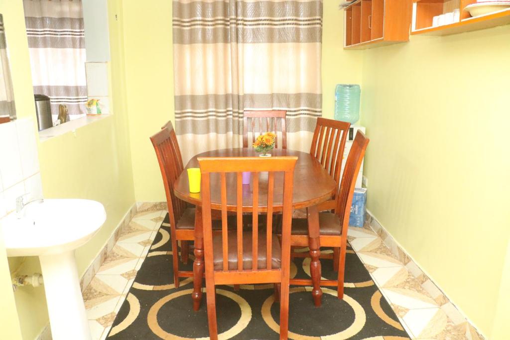 a dining room with a table and four chairs at Lokorye Homes in Makutano
