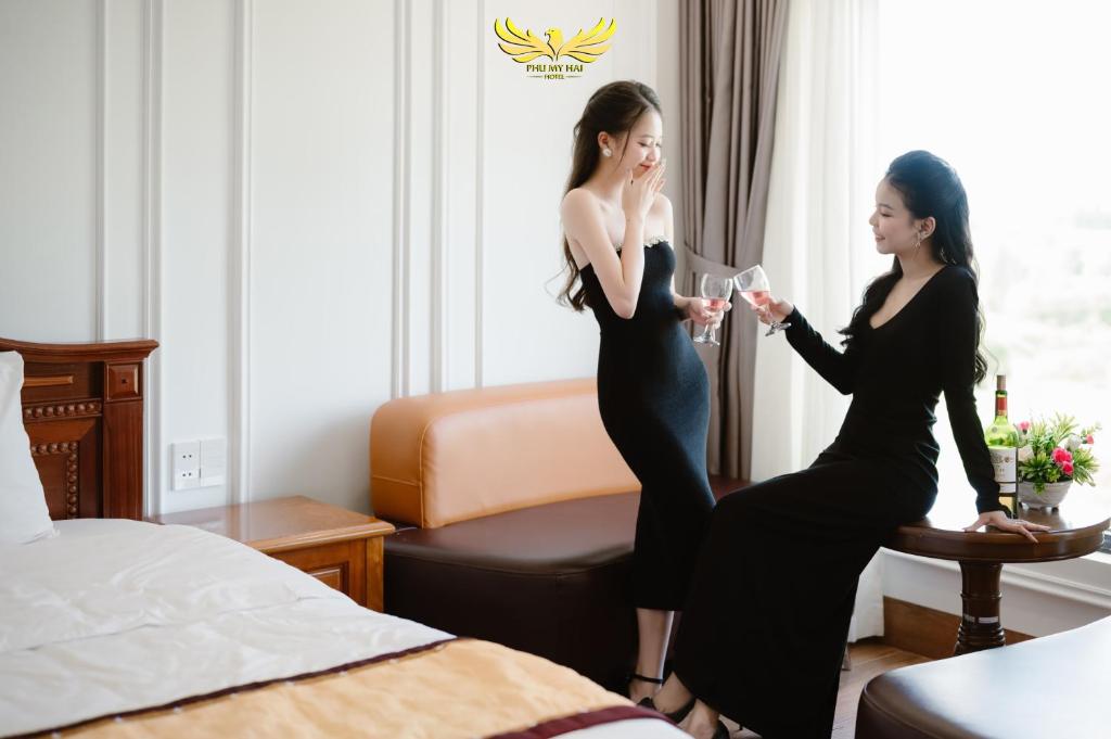 Dos mujeres en una habitación de hotel con copas de vino en Phu My Hai Hotel, en Da Nang