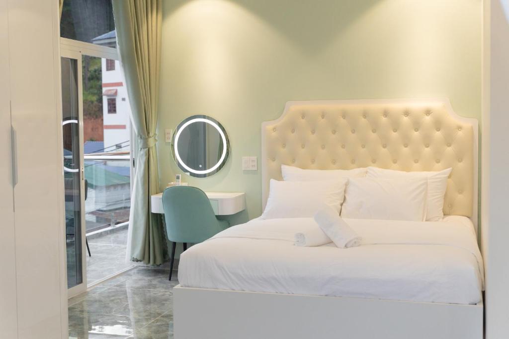 um quarto com uma cama branca e um espelho em Khách Sạn Vinci em Namban