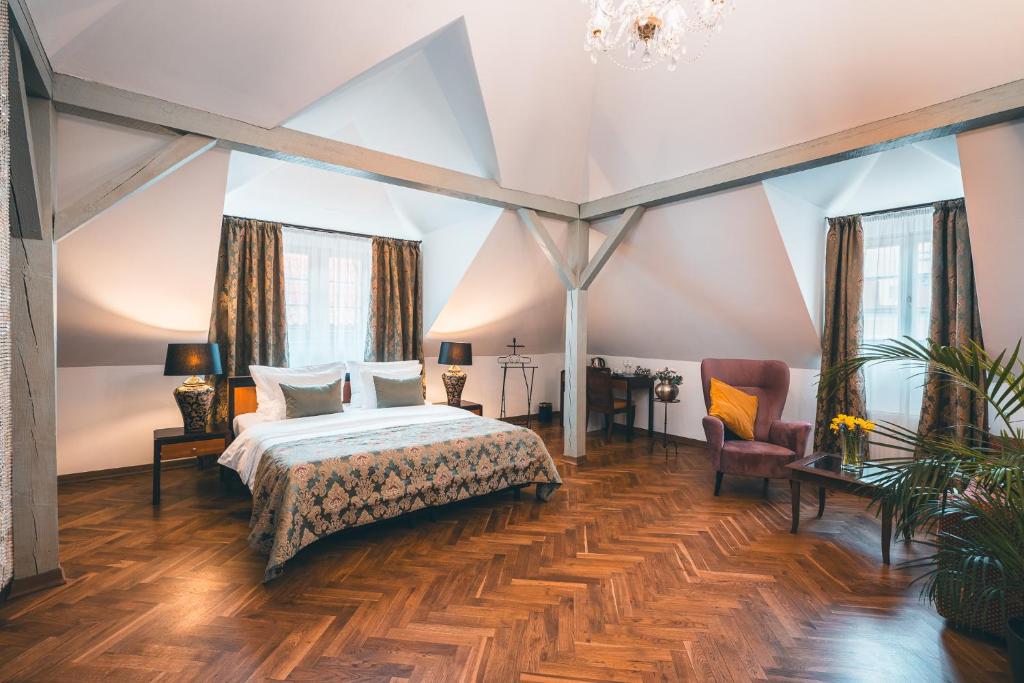 duża sypialnia z łóżkiem i krzesłem w obiekcie Appia Hotel Residences w Pradze