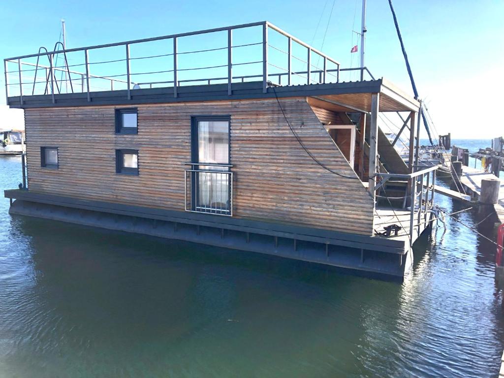 Hausboot - Stina في هايليغنهافن: منزل على رصيف في الماء