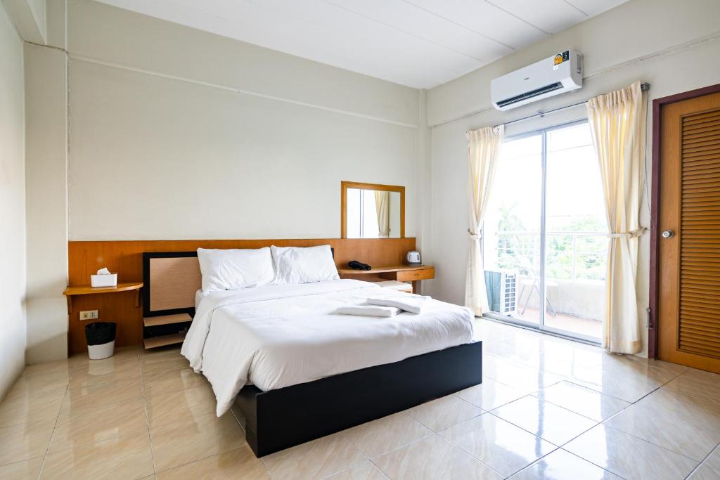 - une chambre avec un grand lit et une grande fenêtre dans l'établissement GO INN Suvarnabhumi Airport โกอินน์ หน้าสนามบินสุวรรณภูมิ, à Lat Krabang