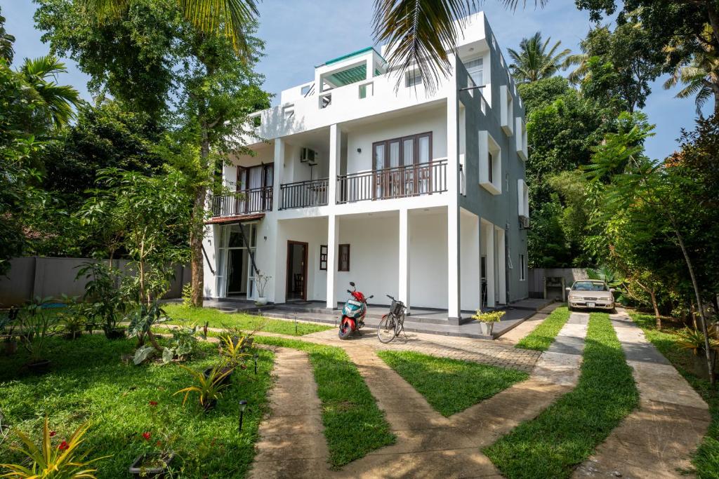 a house with a motorcycle parked in front of it at Villa Ceylanka in Talpe