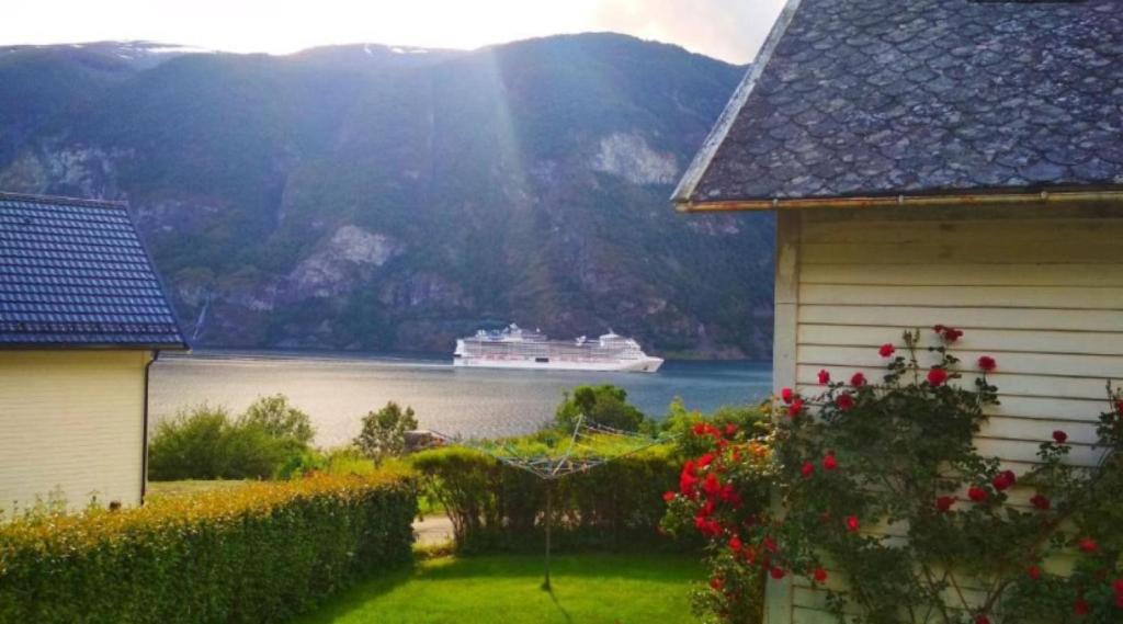 ein Kreuzfahrtschiff im Wasser in der Nähe eines Hauses in der Unterkunft Winjum Hostel Stegastein in Aurland