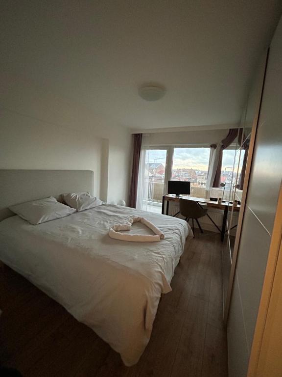 - une chambre avec un lit blanc, un bureau et une fenêtre dans l'établissement Appartement une chambre moderne avec vue imprenable sur le parc et immense terrasse - Idéal pour une escapade urbaine!, à Bruxelles