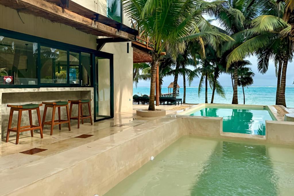 a house with a swimming pool next to the beach at Villa Tankah 7 Cielo in Tulum