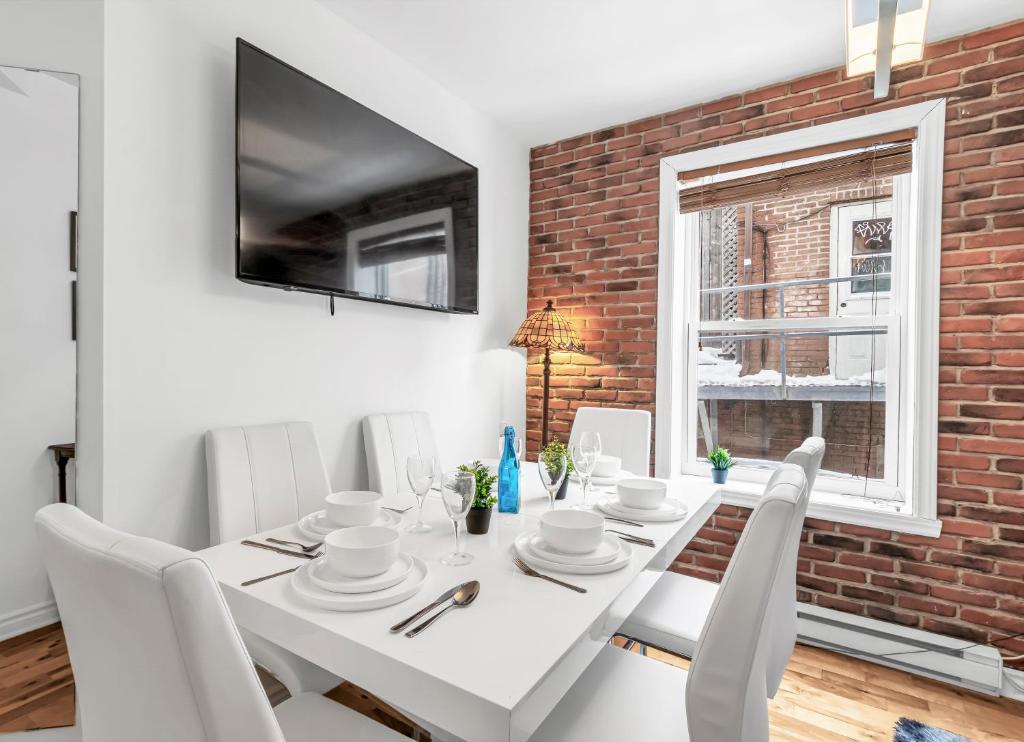 a white dining room with a white table and chairs at DUPLEX FOR GROUP STAY_MONT-ROYAL in Montréal