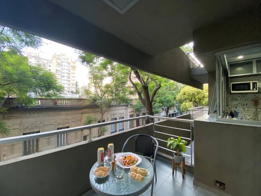 una mesa en un balcón con comida en Céntrico, moderno y cómodo en Rosario