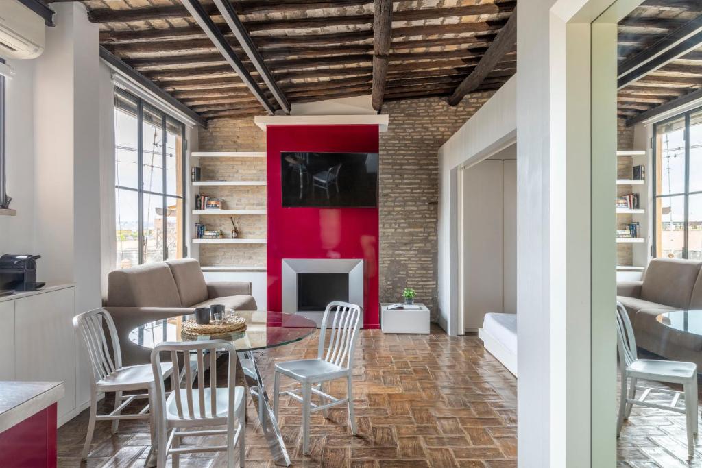sala de estar con mesa, sillas y pared roja en Monti apartment BDB, en Roma