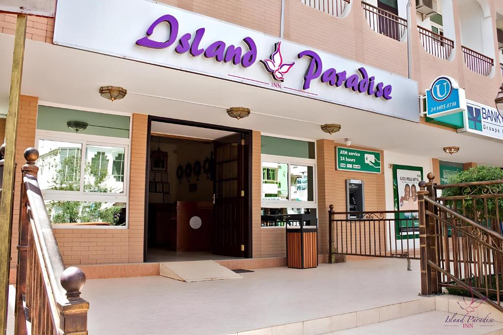 een gebouw met een bord dat alumni praktijk leest bij Island Paradise Inn in Ngambo