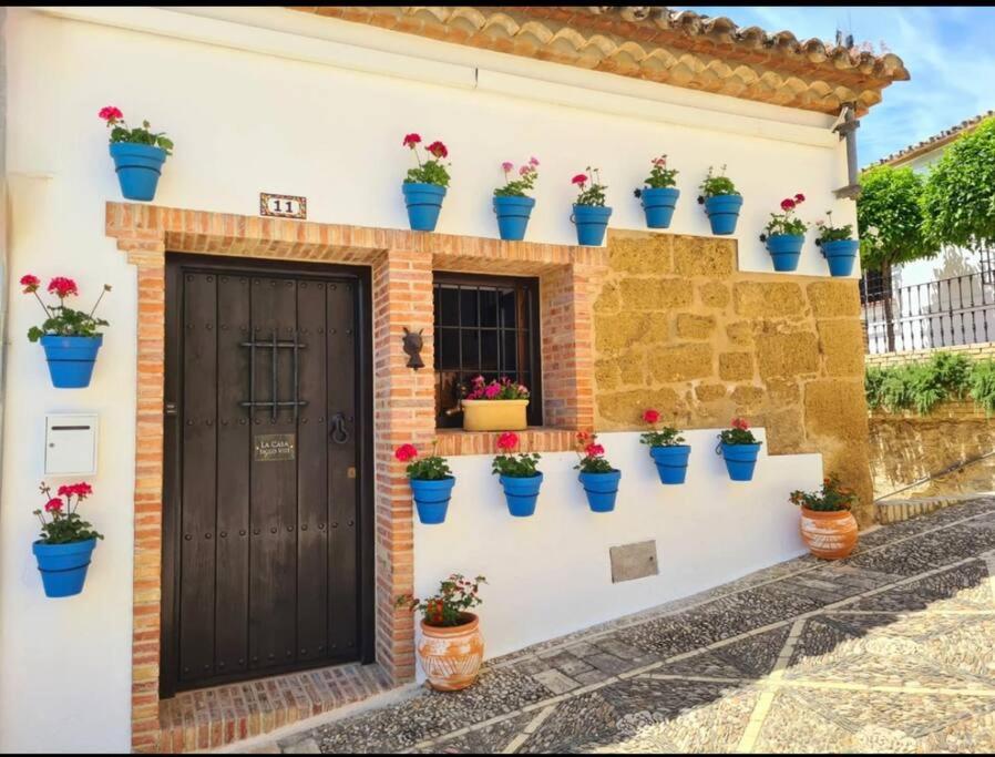 una casa con macetas azules en la pared en La Casa Siglo Ocho, en Iznájar