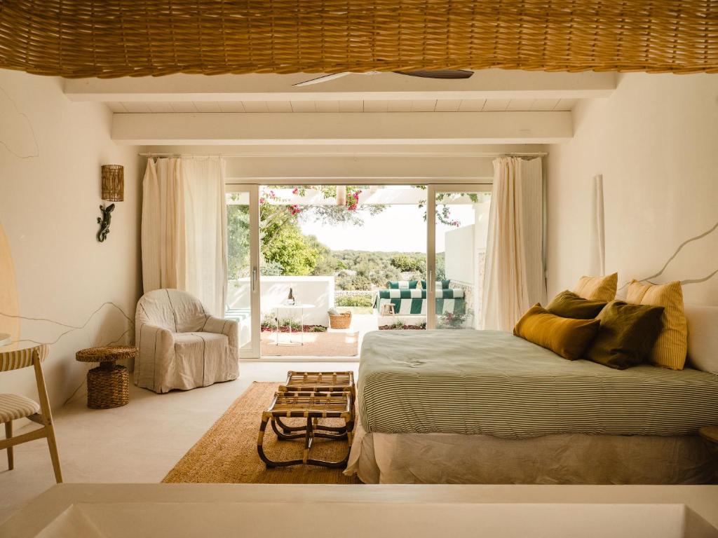 een slaapkamer met een bed en een groot raam bij Morvedra Nou Luxury Boutique Hotel - Adults Only in Ciutadella