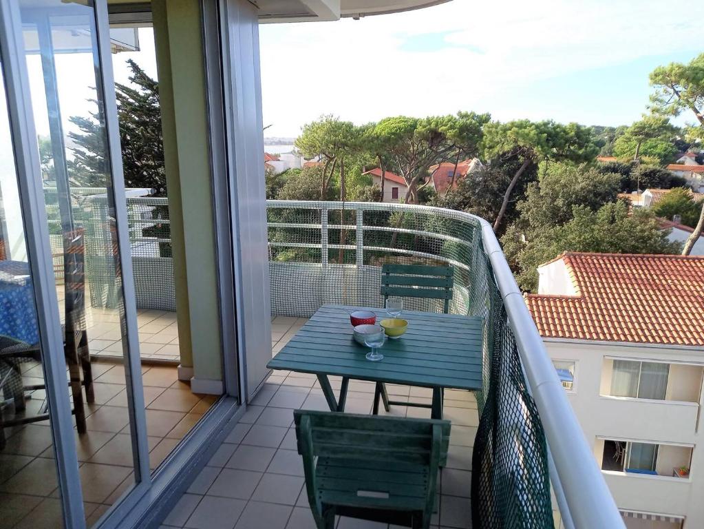 une table bleue sur un balcon avec vue dans l'établissement Royan Parc - APPARTEMENT - résidence LA GRANDE HUNE - APERCU MER, à Royan