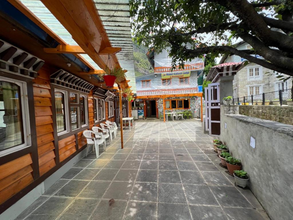 een loopbrug tussen twee gebouwen met tafels en stoelen bij Mount kailash lodge and resturant , Monjo in Monjo