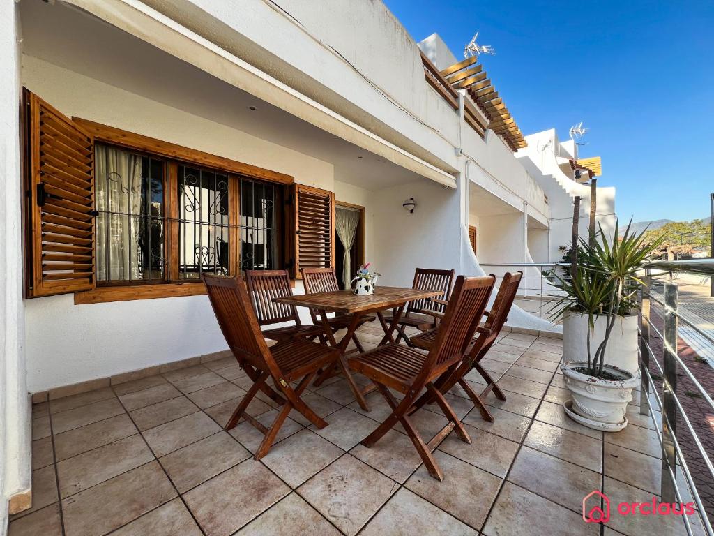 貝尼卡西姆的住宿－La Casa Ibicenca，阳台的天井配有木桌和椅子