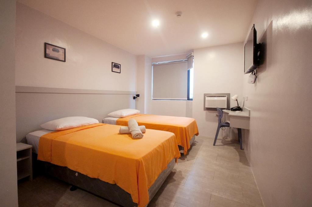 Habitación con 2 camas, escritorio y lavabo. en Hotel Lucca, en Legazpi