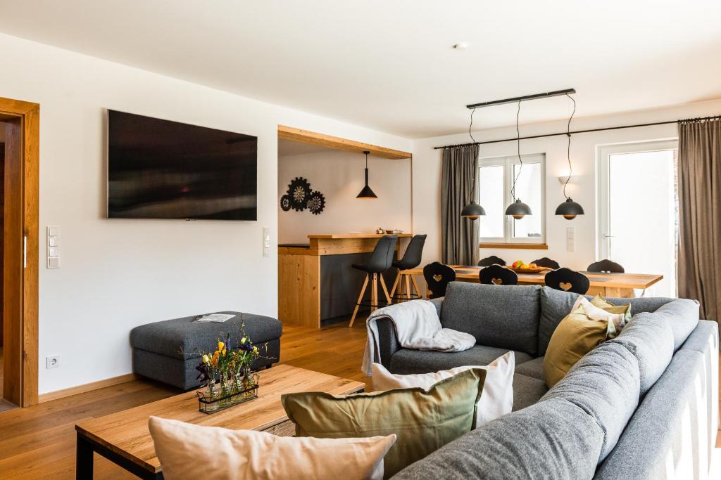 ein Wohnzimmer mit einem Sofa und einem Esszimmer in der Unterkunft Haus Alpspitzchalet 32 in Garmisch-Partenkirchen