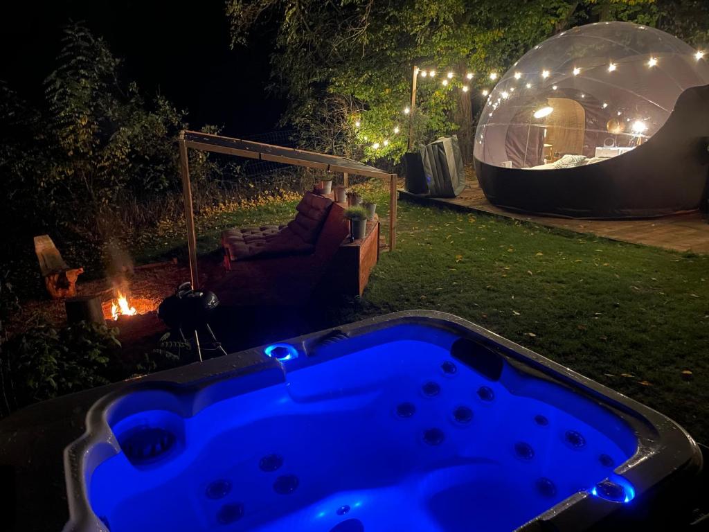 una vasca idromassaggio in un cortile di notte con un igloo di La bulle bien belge avec jacuzzi a Lasne