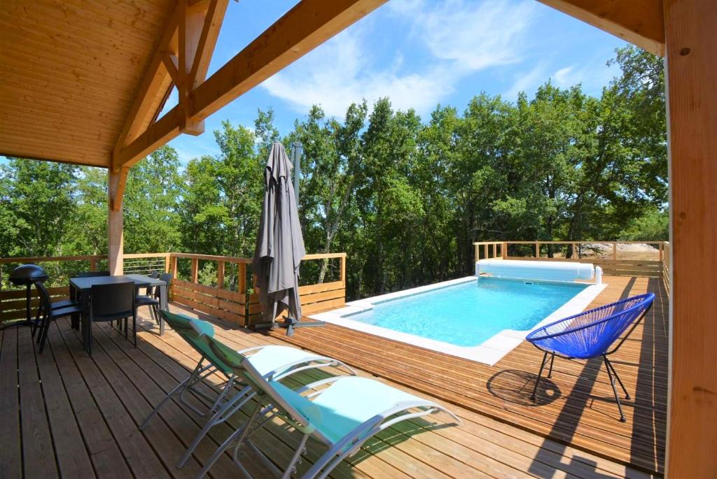 une terrasse avec une piscine, des chaises et un parasol dans l'établissement Maison CLAPAS, à Saint Alban Auriolles