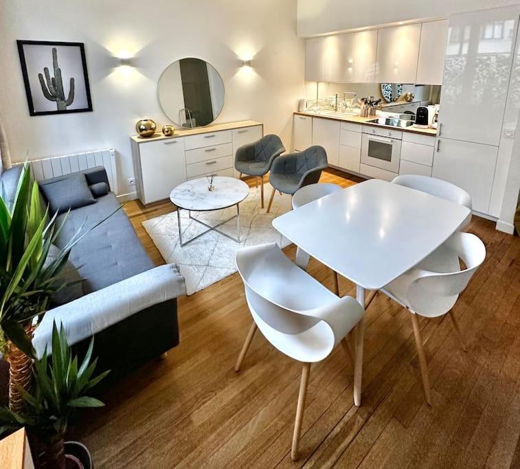 sala de estar con mesa blanca y sillas en Appartement 50m2 avec terrasse idéalement situé, en Boulogne-Billancourt