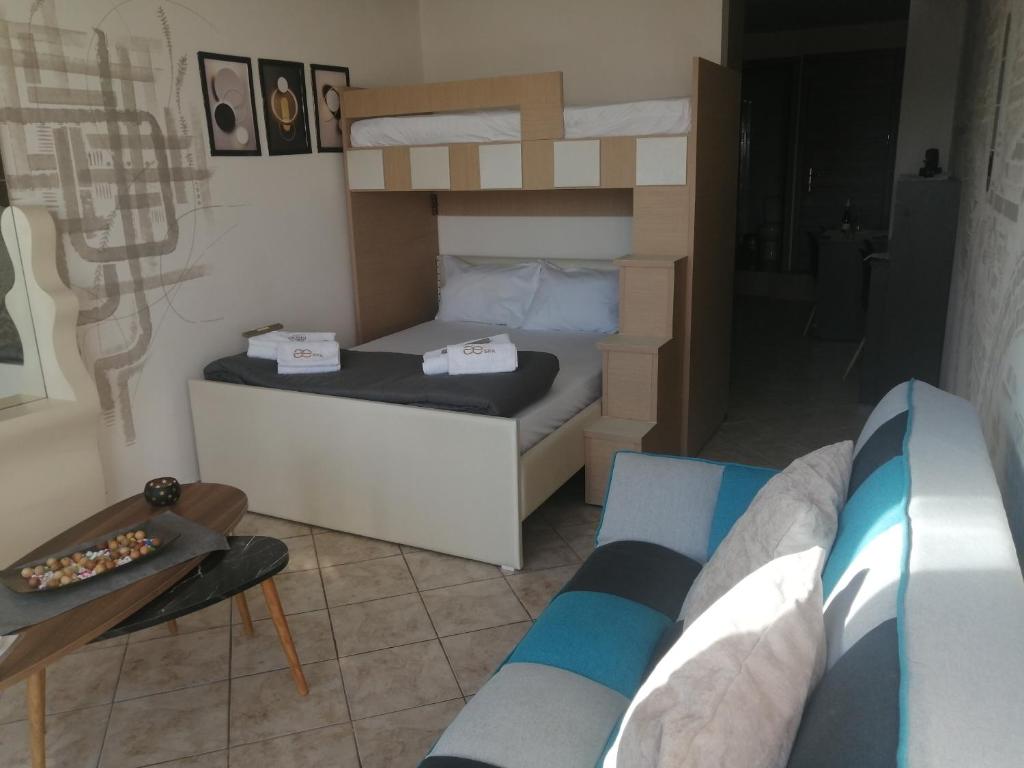 een kleine slaapkamer met een stapelbed en een bank bij Sunshine Apartment 2 in Alexandroupoli