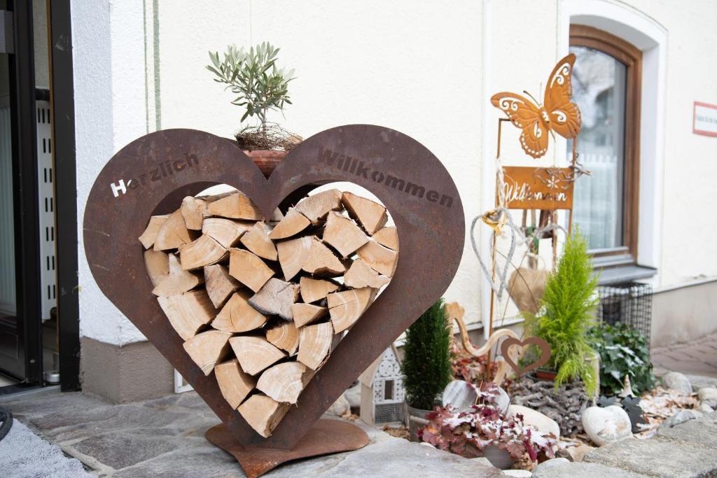 a couple of heart shaped logs in front of a building at Hotel Bockmaier in Oberpframmern