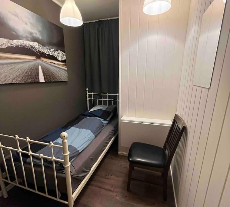 a small bedroom with a bed and a chair at Cozy miniroom A in Åmot