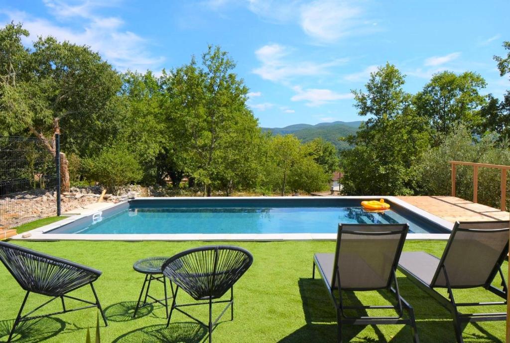une cour avec une piscine, des chaises et une table dans l'établissement Mas GEORGES, à Saint Alban Auriolles