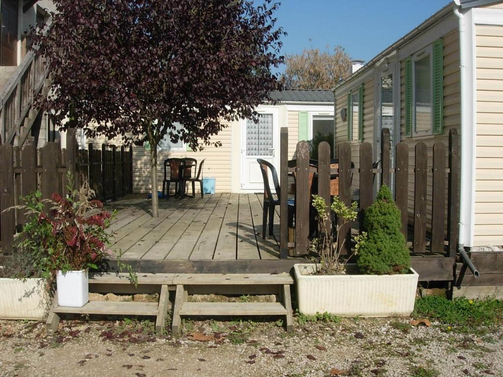 eine Holzterrasse mit einem Tisch und Stühlen auf einem Haus in der Unterkunft Mobile-Home 1 "Ognon" in Pesmes