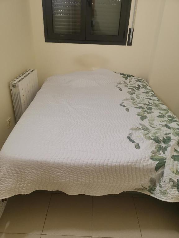 a bed in a bedroom with a white bedspread with flowers on it at one Room in Almenar
