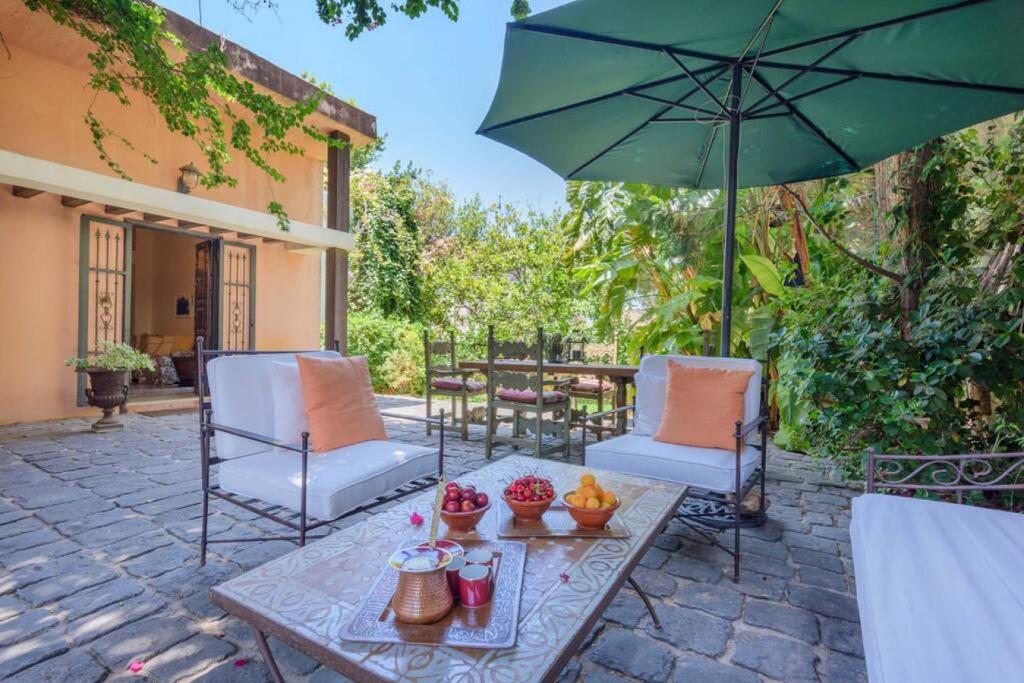 eine Terrasse mit einem Tisch, Stühlen und einem Sonnenschirm in der Unterkunft La Madrague 3 Bedroom Villa with Garden in Batroun in Batrun