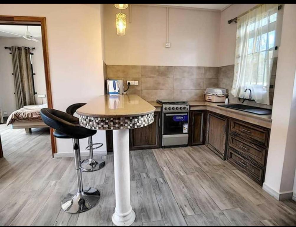 a kitchen with a table and two bar stools at Modern 1 -Bed room Apartment in Grand Baie in Grand Baie