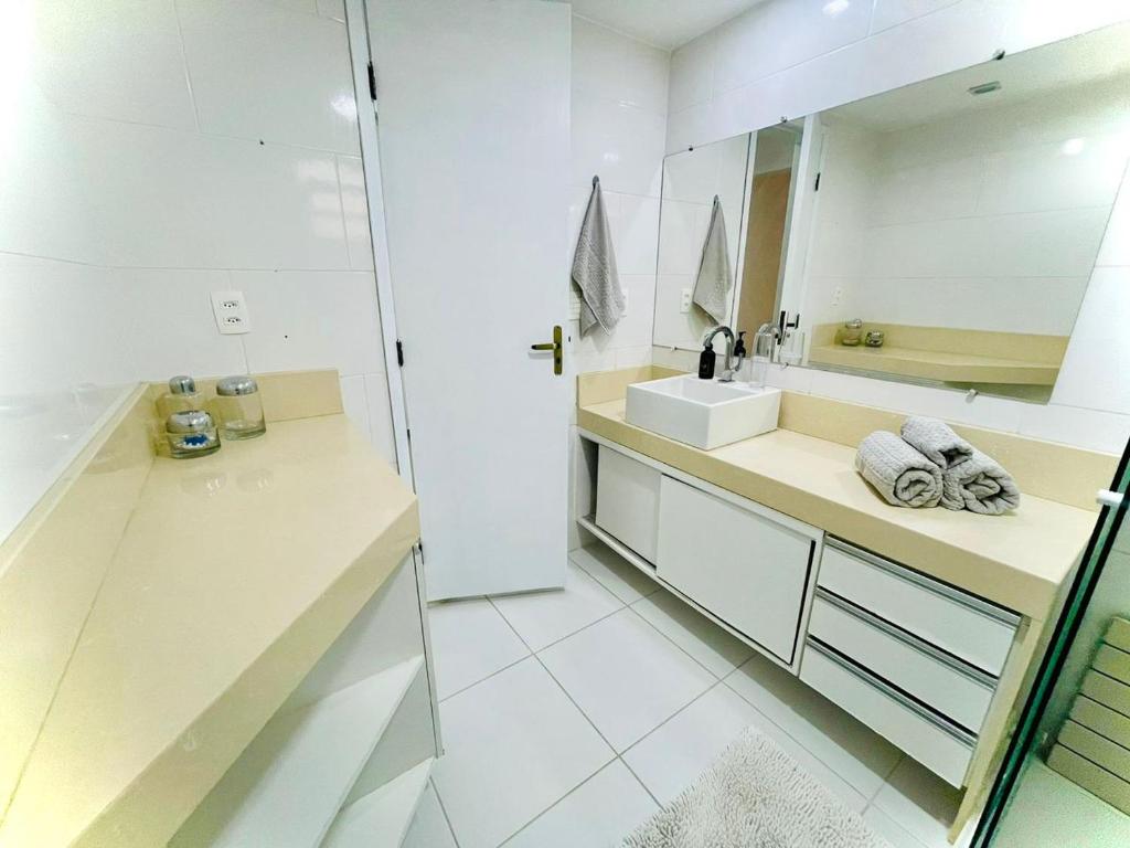 Baño blanco con lavabo y espejo en Hospedagem Caminho das Praias en Niterói