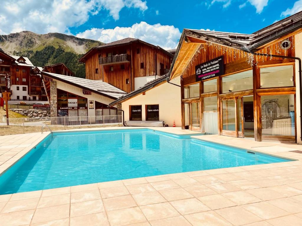 a large swimming pool in front of a building at Les Orres 1800 - 6 places Plein Sud avec Piscine in Les Orres