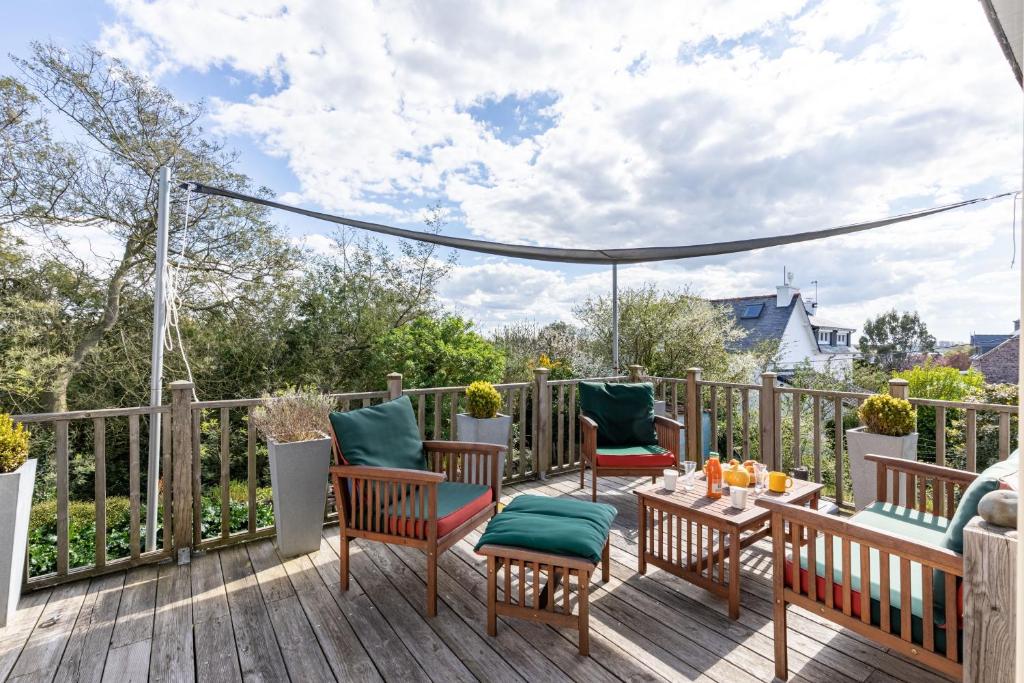 a patio with chairs and a table on a deck at Ker Helly - Belle Maison avec Terrasse à Fréhel in Frehel