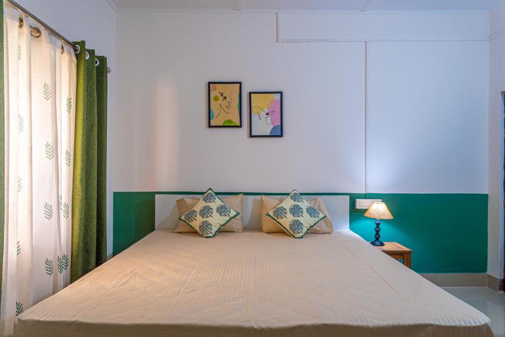 a bedroom with a bed with a green and white wall at Mulaqat Homestay in Siliguri